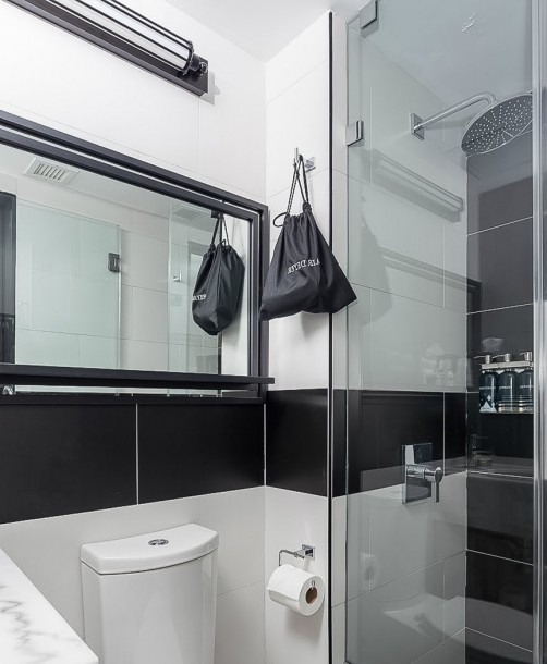 bathroom with black and white tile, walk in shower, and vanity area
