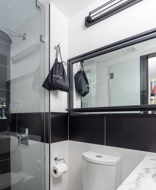 guest bathroom with black and white tile and a walk in glass shower