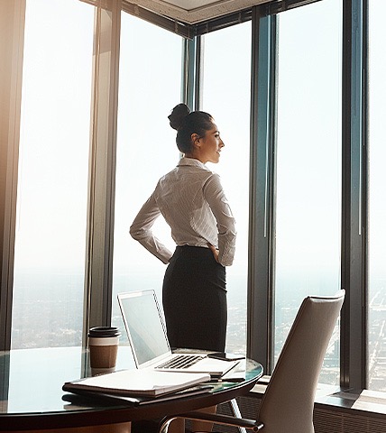 business woman standing in front of floor to ceiling windows
